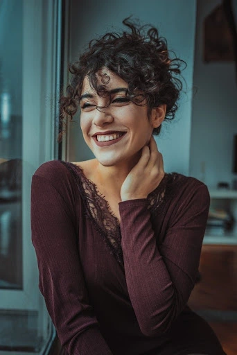 a woman smiling with her hand on her neck