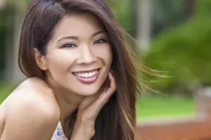 a woman smiling with her hand on her face