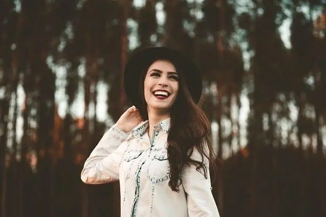 a woman smiling with a hat