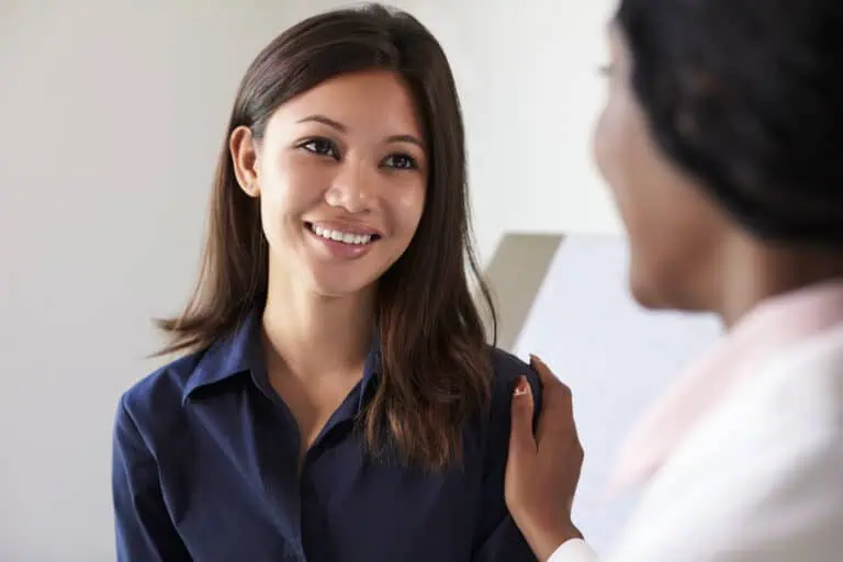 a woman smiling at another woman