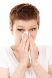 a woman with short hair wiping her nose