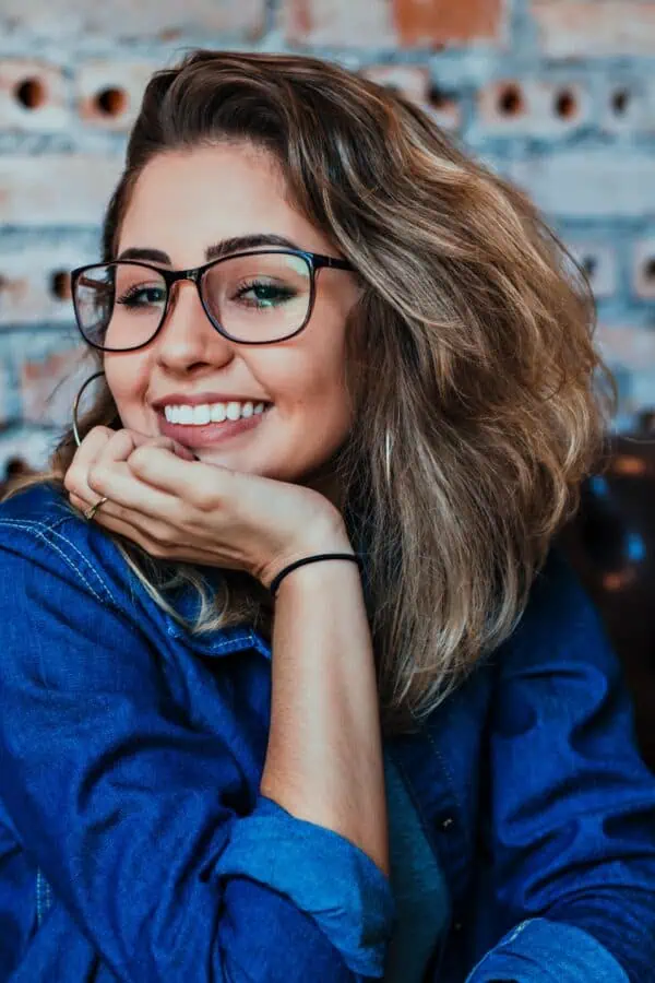 a woman with glasses smiling