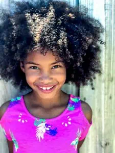 a girl with curly hair smiling