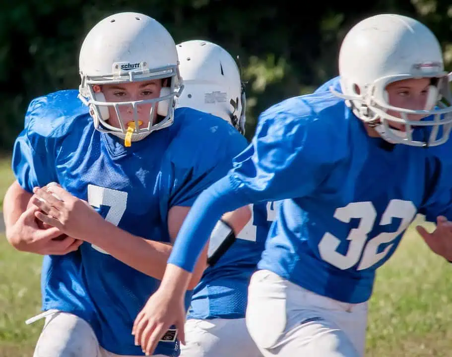 a group of people in football uniforms running