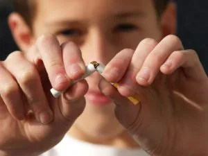 a close-up of a boy breaking a cigarette