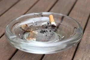 a cigarette butts in a glass ashtray