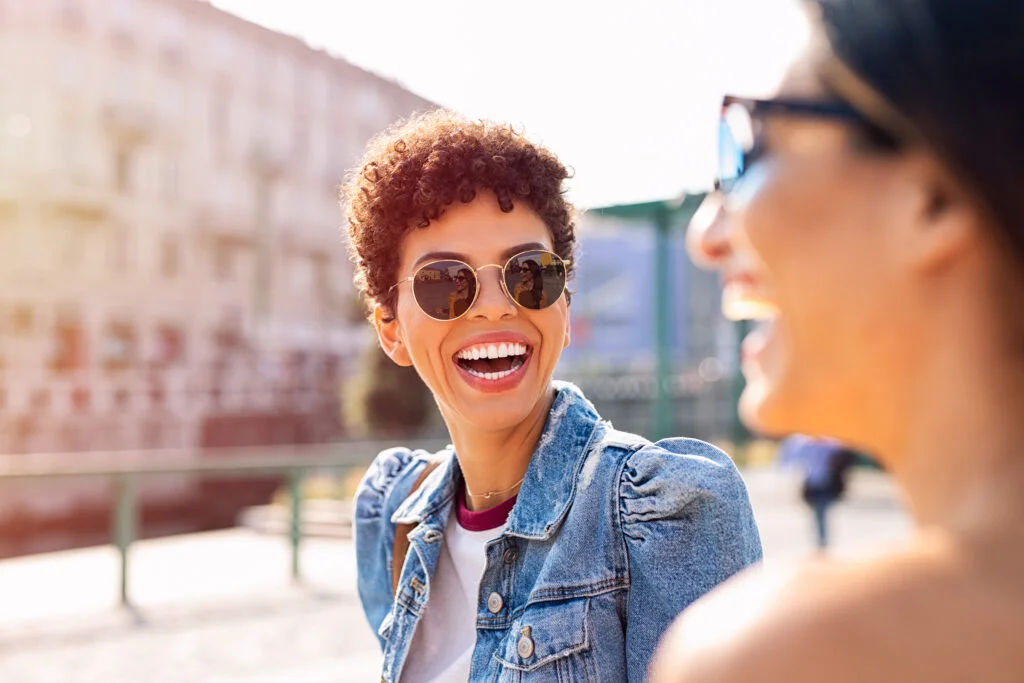 a woman laughing with sunglasses