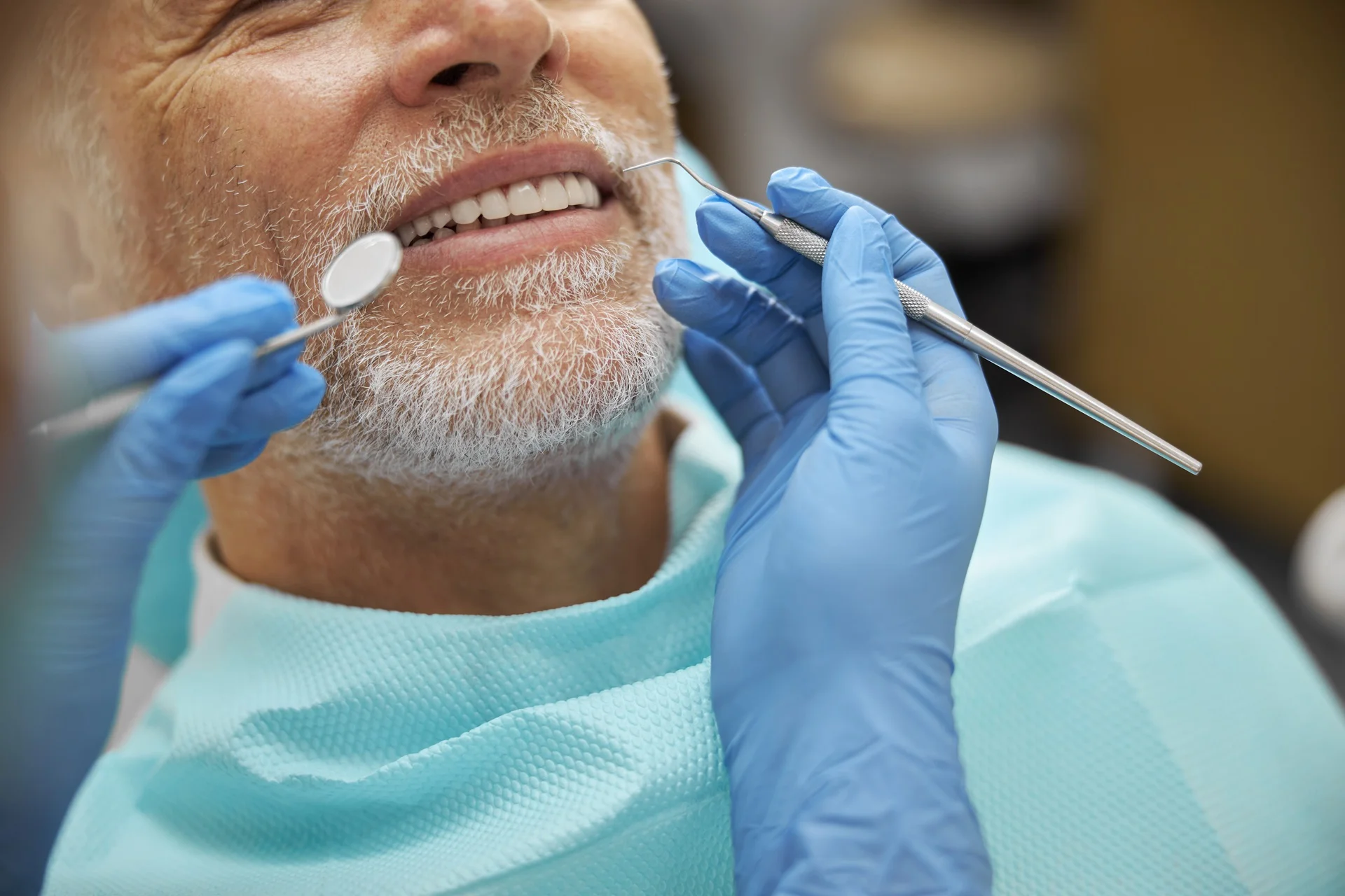 a dentist holding a dental tool to a man's mouth