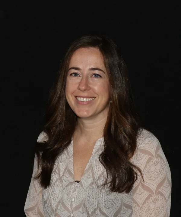 a woman with long brown hair smiling