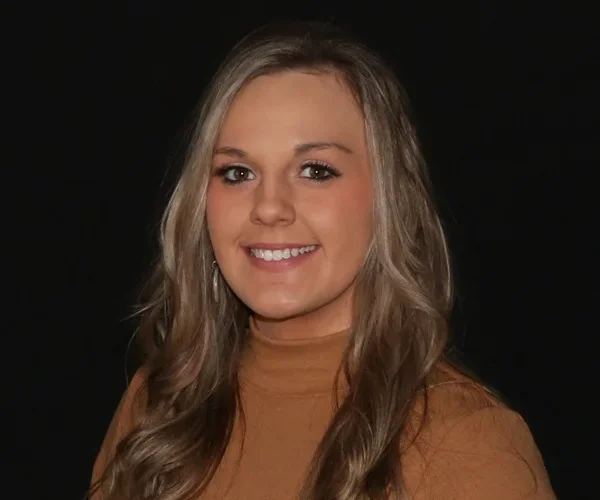 a woman with long hair wearing a brown turtleneck