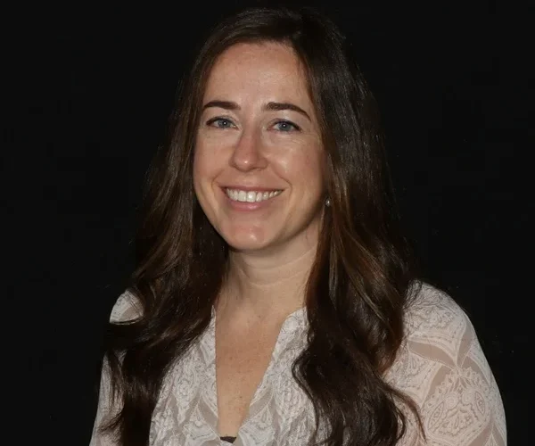 a woman with long brown hair smiling