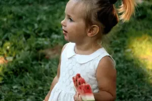 a little girl holding watermelon